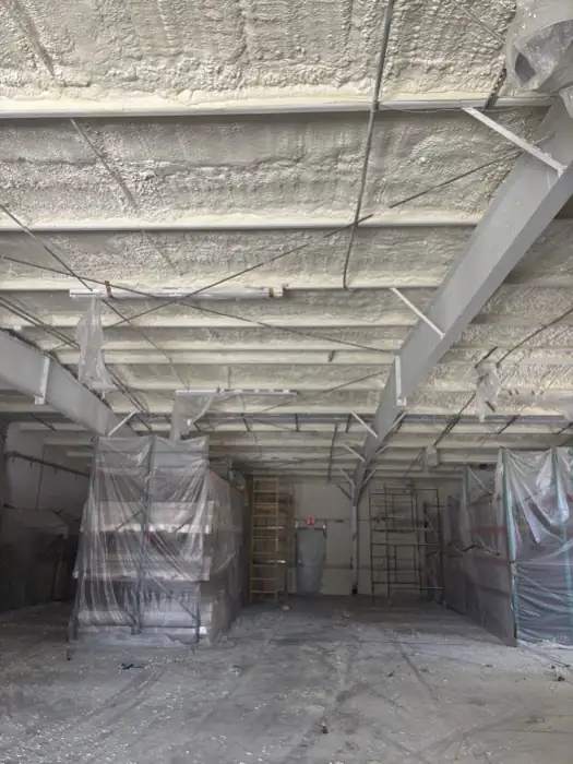 Spray foam applied to the full roof deck of a commercial building between steel beams