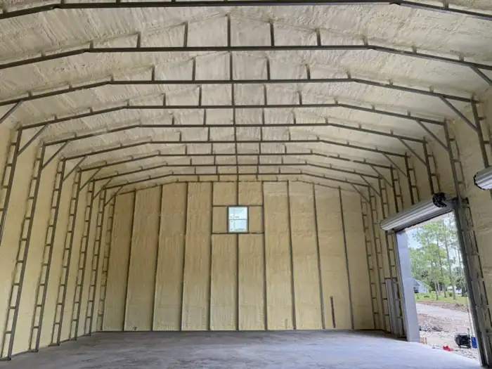 Spray foam covering the roof deck and end wall of a steel garage building
