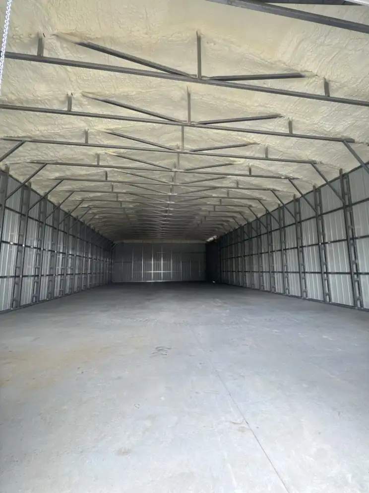 Closed-cell spray foam sprayed between the roof purlins of a metal building