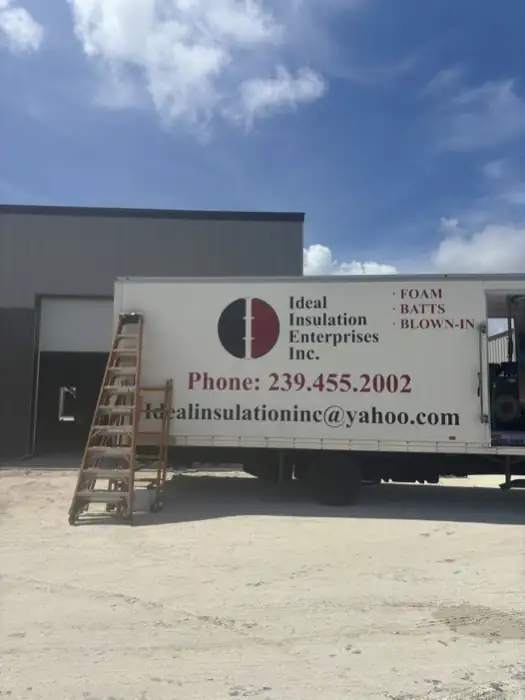 Ideal Insulation box truck with the company phone number, parked at a Southwest Florida jobsite